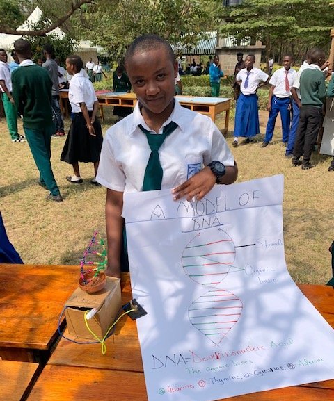 A student at Mtakuja Secondary School displays the DNA model she constructed.