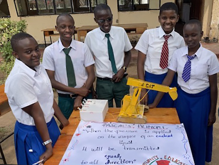 Students from Mtakuja Secondary School display an artifact demonstrating Pascal’s Principle of hydraulics.
